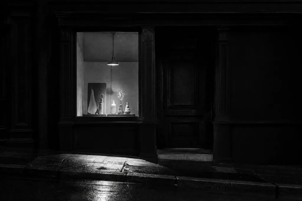 Closed shop at night with one lit display window
