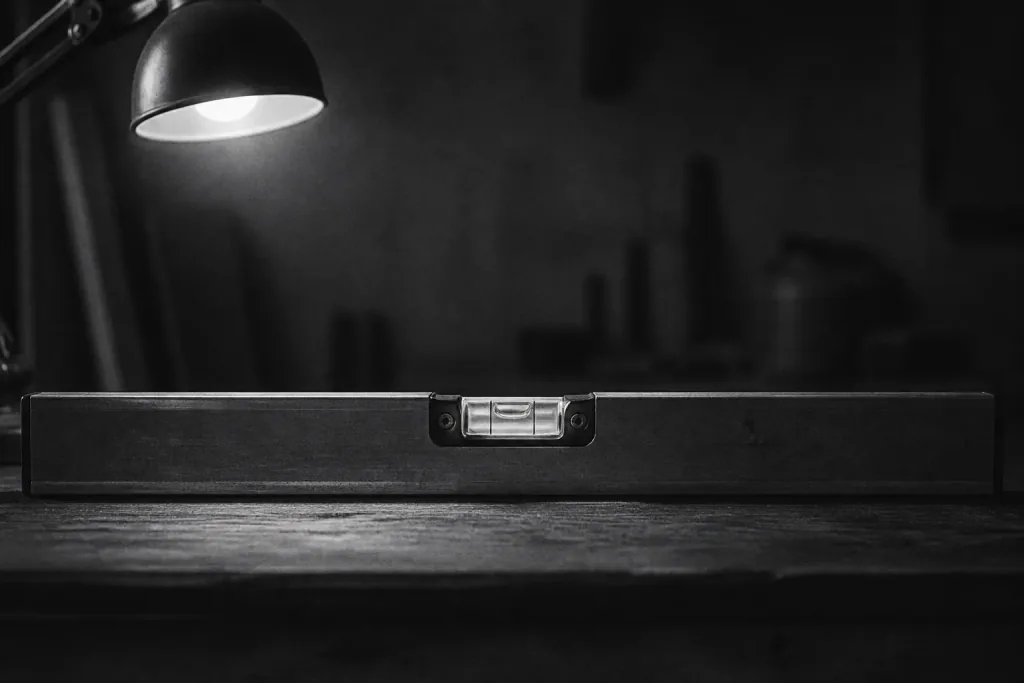 A spirit level on a dark desk, the bubble sitting in the centre